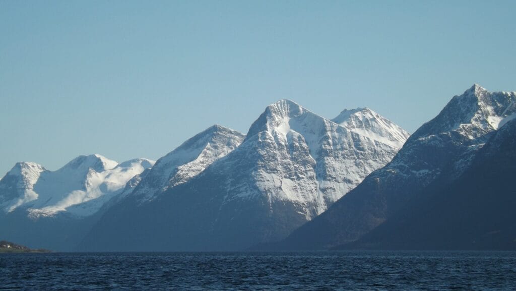 Steep Norwegian fjord with turquoise water and alpine peaks near Hjørundfjord, one of the top hidden gems in Norway