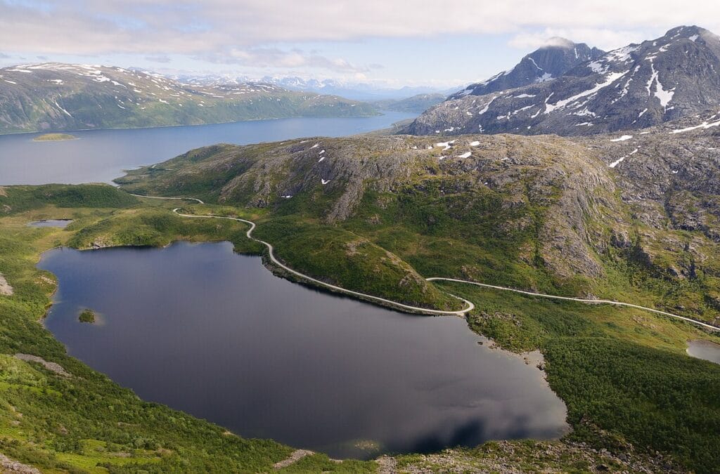 Coastal road on Kvaløya island with mountains and sea, part of the Kvaloyvagen beach route popular with local aurora hunters