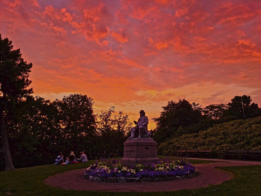 St. Hanshaugen park in Oslo with trees, grass and a quiet walking path on a sunny day
