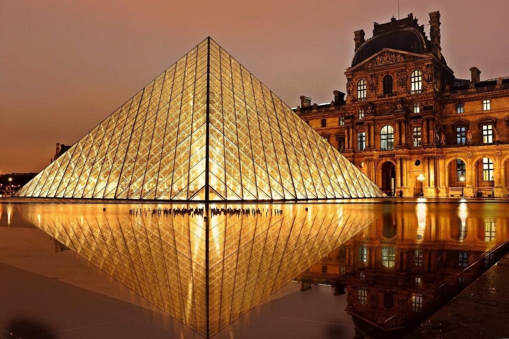 Louvre Museum building exterior with wheelchair accessible entrance via central pyramid elevator, accessible route for disabled travelers visible