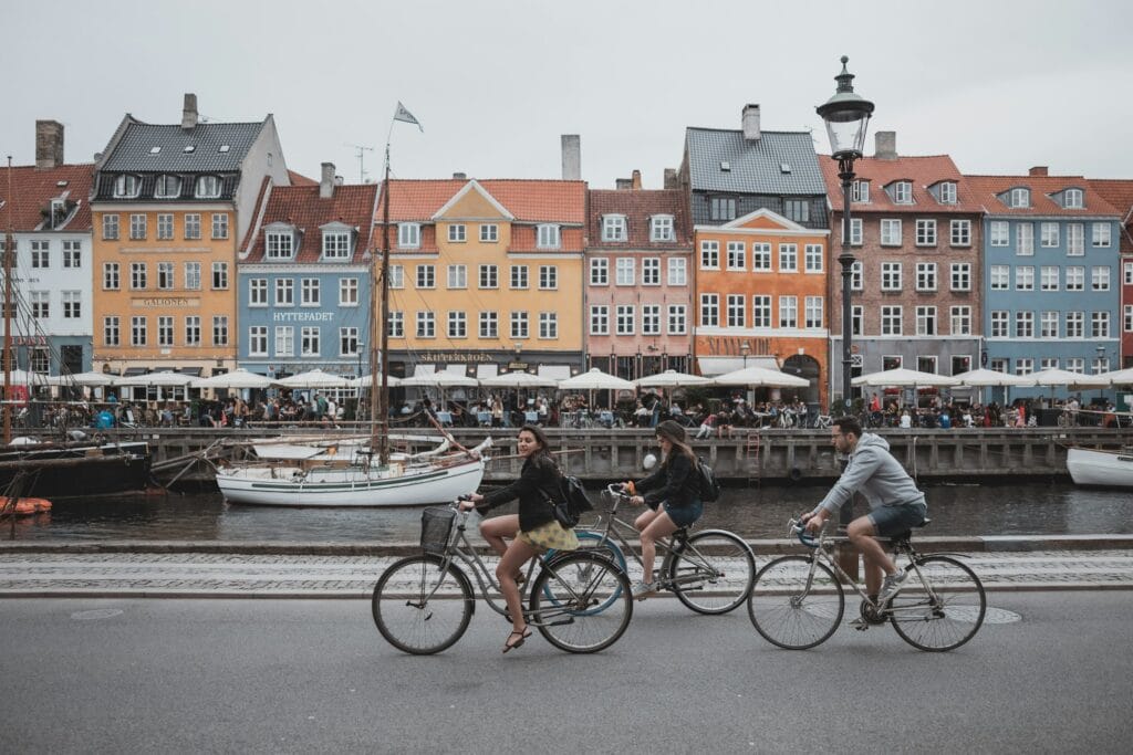 "People riding bicycles in Copenhagen, Denmark representing the bike-friendly and safe culture for solo female travelers"