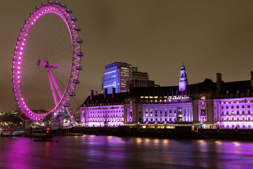 London Eye lit up at night above the Thames with a step-free boarding area for wheelchair users