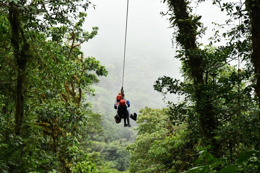 Family members zip-lining through rainforest canopy in Costa Rica, exciting adventure activity for kids and parents