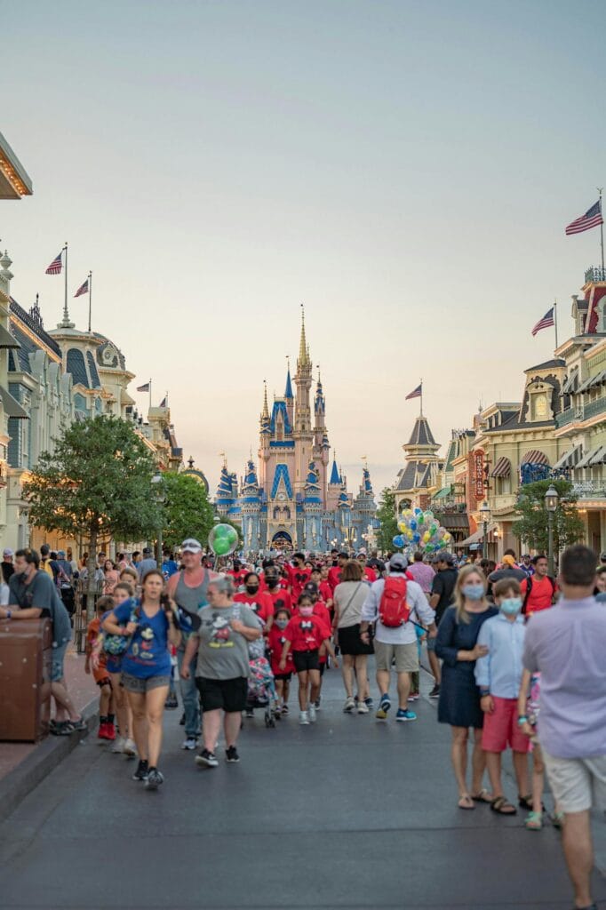 Cinderella Castle at Disney Magic Kingdom with families walking and crowds, iconic theme park family vacation destination