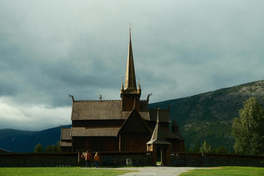 Dark wooden Norwegian stave church under moody skies, representing the 12th‑century Høre Stave Church in Valdres