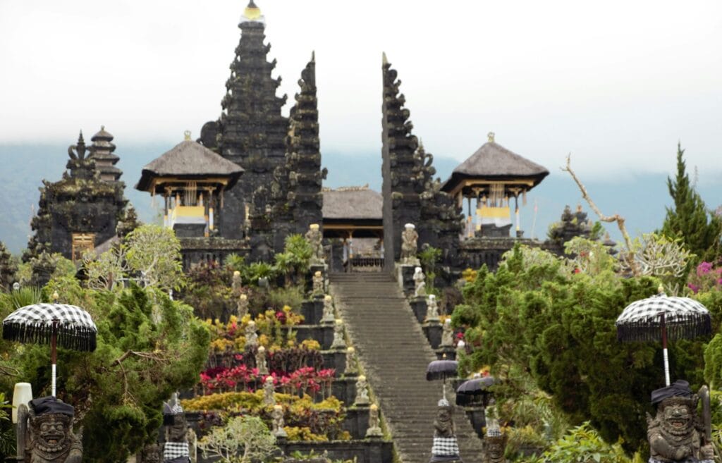Bali Indonesia traditional temple with intricate golden decorations and multiple roofs, spiritual budget beach destination