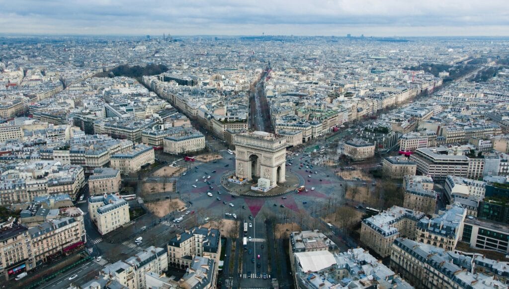 "Aerial view of Arc de Triomphe in Paris roundabout, showing monument accessibility challenge of 30 underground steps, requiring advance planning for wheelchair access