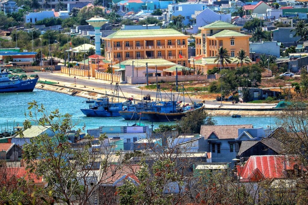 Vietnam Da Nang port with colorful fishing boats and buildings, cheap backpacker beach town perfect for budget summer travel