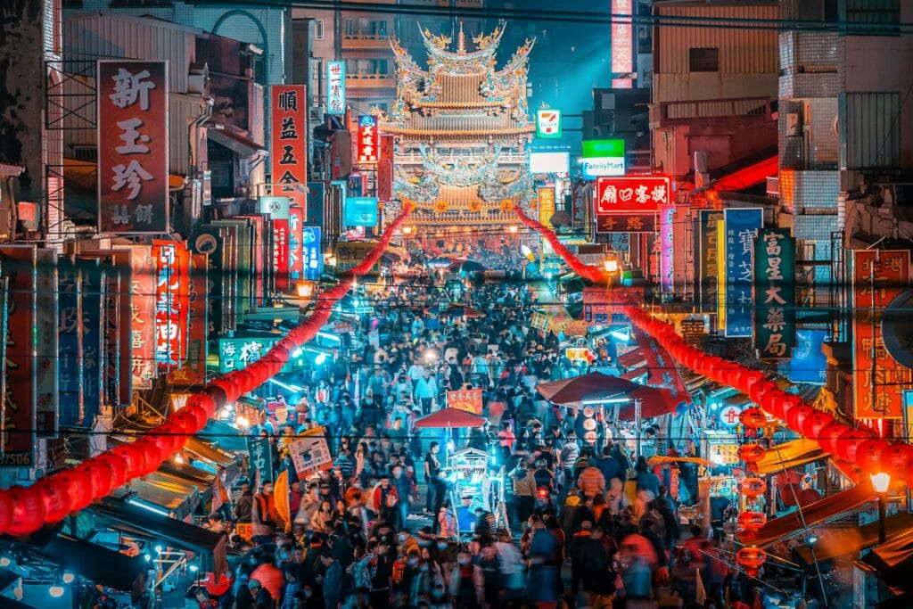Taiwan night market with colorful food stalls and crowds buying street food, affordable Asian destination