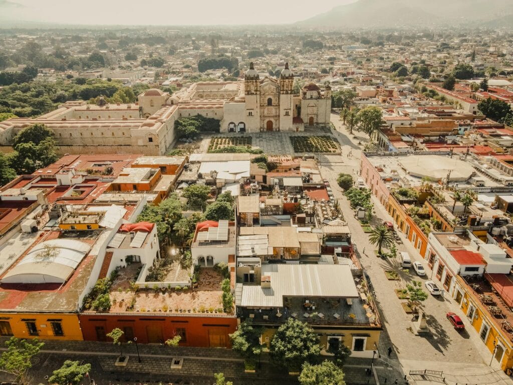 Drone perspective of the colorful colonial buildings and grid-like streets of Oaxaca City.