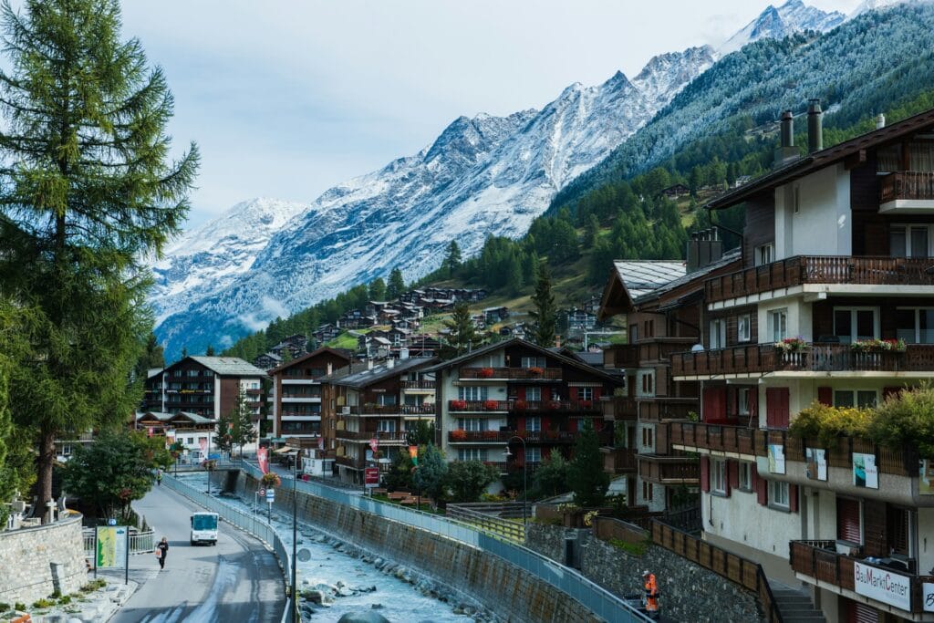 Traditional wooden Swiss alpine chalets situated along a mountain valley path in the car-free village of Zermatt, Switzerland.