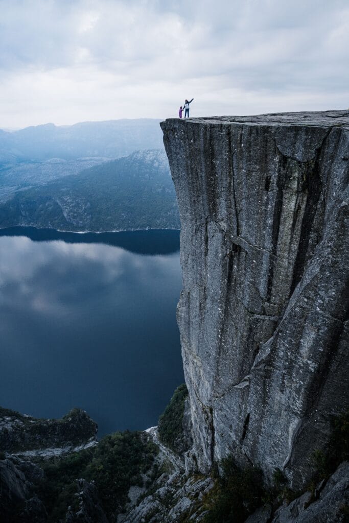 Breathtaking view from a high cliff overlooking a deep blue Norwegian fjord in the Sunnmøre region.