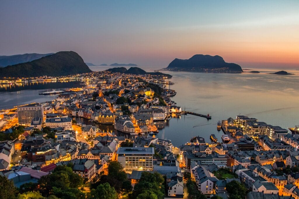 Aerial view of Ålesund city surrounded by sea at sunset, highlighting an underrated Scandinavia travel destination.