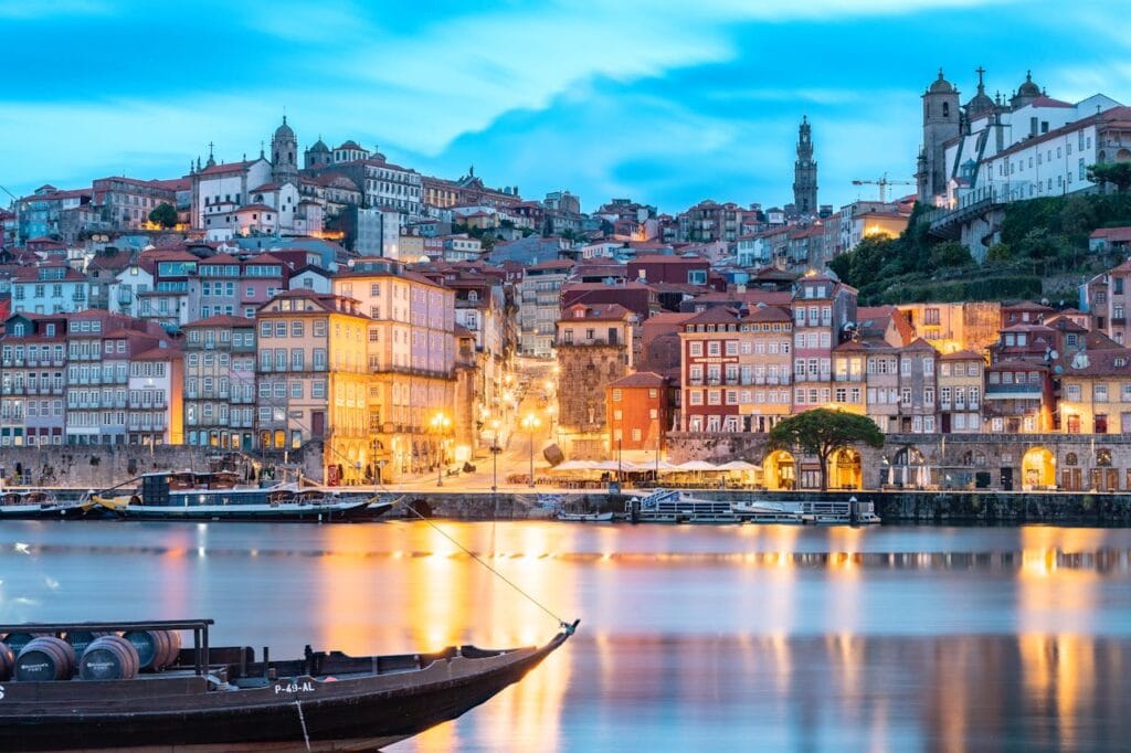 A narrow, picturesque historic street featuring traditional tiled Portuguese building facades and balconies in Porto, Portugal.