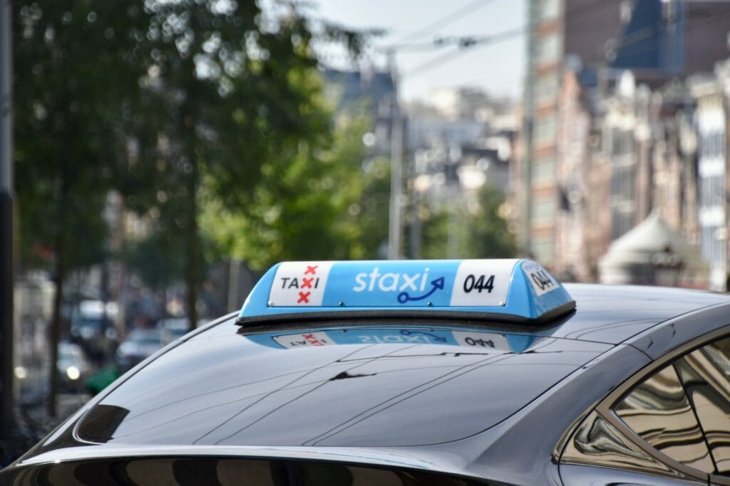 Taxi sign on a car in Amsterdam, representing wheelchair-accessible taxi and ride-share service