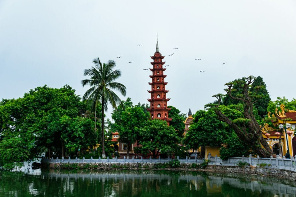 Tall historic tower next to a scenic body of water in Hanoi, Vietnam, during the pleasant autumn transition