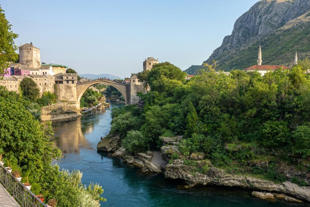 Brown concrete bridge over a river in Bosnia and Herzegovina during a sunny day