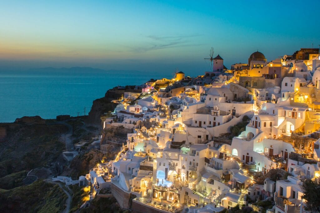 White and brown cave houses on the cliffside of Oia, Santorini, overlooking the caldera during daylight