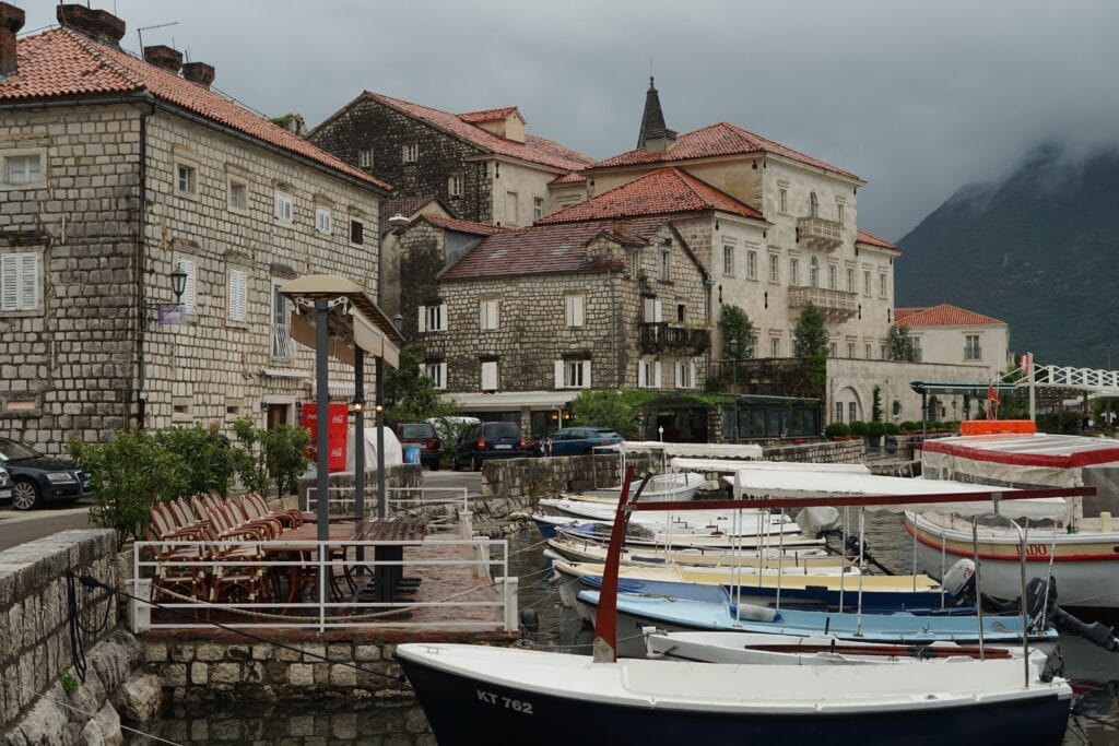 Concrete houses near the harbor with boats in a scenic Montenegro coastal town